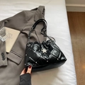 Detailansicht der schwarzen gesteppten Beuteltasche mit Sternen und Kette auf weißem Tisch - Schwarz
