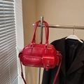 Detaillierte Nahaufnahme einer roten Bowling-Tasche mit glänzenden Silberbeschlägen - Rot