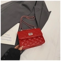 Detail of red quilted crossbody bag with silver chain strap and metal turn lock closure - Red