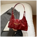 Detailansicht einer dunkelroten glänzenden Leder-Achseltasche mit goldener Schnalle - Rot