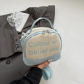 Detail van blauw-witte canvas crossbodytas met handvat aan de bovenkant en metalen rits - Blauw