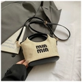 Detail of handwoven straw bucket bag with black leather handle and embroidered logo - Black without Pendant