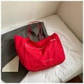 Detail view of red oversized tote bag with San Francisco print on a cozy bed background - Red