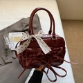 Dettaglio borsa in pelle verniciata bordeaux con tasche a fiocco e sciarpa a pois - Borgogna