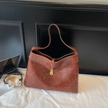Détail de la texture cuir vintage du sac cabas marron avec boucle dorée élégante - Marron