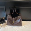 Détail du grand sac cabas en cuir marron foncé avec élégant pendentif gourde dorée - café