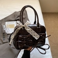 Detail of dark brown retro leather handbag with bow pockets and polka dot silk scarf decoration - Coffee