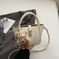 Detail of cream bucket bag with lychee texture leather and a cute plush bear charm - Cream White with Pendant