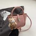 Pink lychee texture leather bucket bag with cute bear charm and silver twist lock detail - Pink With Pendant