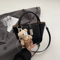 Detail of black lychee grain bucket bag with teddy bear charm and metal buckle - Black With Pendant