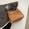 Detalle de bolso tote de cuero marrón con cierre de giro plateado y tacos de metal - Marrón Amarillento