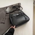 Vista detallada del bolso tote negro con hebilla plateada y pies de protección de metal - Negro