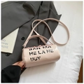 Primer plano de un bolso cilíndrico rosa con letras impresas sobre un traje gris claro - Grande / Rosa