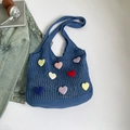 Dettaglio della borsa tote blu all'uncinetto con toppe a cuore colorate e maglia traforata - Blu scuro