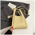 Dettaglio borsa a secchiello in pelle martellata giallo chiaro con scritta fashion - Giallo con ciondolo