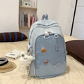 Detail of light blue school backpack with transparent mesh pocket and plush dog charm - Blue With Doll