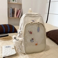 Detalle de mochila de lona blanco roto con bolsillo de malla transparente y parches lindos - Blanco Con Muñeco
