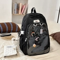 Detalle de mochila ita negra con bolsillo de PVC para pines y colgante de osito - Negro Con Muñeco