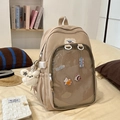 Detalle de mochila de nailon beige con ventana de PVC transparente y adornos lindos - Caqui Con Muñeco