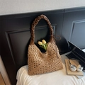 Dettaglio della borsa tote in paglia intrecciata con manico in pelle marrone e uncinetto - Cachi