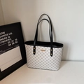 Detalle del bolso tote blanco roto con estampado de monograma gris y placa de metal dorado - Negro