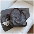 Detalle del bolso tote gris vintage con textura suave, asas de cuero y colgante de oso - Negro (con colgante)