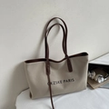 Close-up of cream canvas tote bag with leather straps and black PARIS lettering print - Khaki and Black