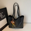 Détail d'un sac cabas noir minimaliste en cuir avec une adorable peluche d'ours et une étoile - Noir Avec Pendentif