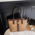 Detail view of large brown faux leather tote bag with metallic accents and shoulder straps - Khaki