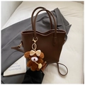 Detail of dark brown pebble leather tote bag with wavy trim and cute bear charm - With Charm / Brown