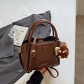 Brown litchi grain tote bag with handles and adjustable strap featuring a plush charm - Brown with Pendant