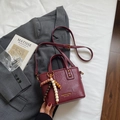 Détail du sac seau bordeaux avec perles en bois et logo doré sur tissu doux - Bordeaux (Avec Pendentif) / Rouge Ankara Avec Pendentif