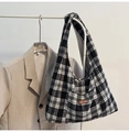 Detail of black and white checkered canvas tote bag with brown leather brand tag - White