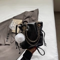 Bolso saco negro moderno con cordón ajustable, cadena dorada y pompón blanco de adorno - Negro