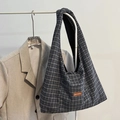 Japanese houndstooth canvas tote bag with brown leather label hanging on rack - Black