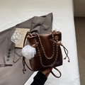 Brown leather bucket bag with gold chain strap and decorative white fluffy pendant charm - Brown with Pendant