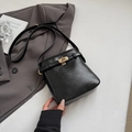 Minimalistische schwarze quadratische Umhängetasche mit goldenem Drehverschluss auf Blazer - Ohne Anhänger / Schwarz