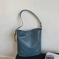 Detailansicht der dunkelgraublauen geflochtenen Beuteltasche mit Perlenanhängern und Textur - Islandblau