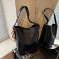 Black leather bucket bag with artistic wooden beaded charm for chic commuting style - With Charm / Black