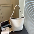 Off-white marbled bucket tote bag with wide strap and wooden bead charm on office desk - With Charm / White