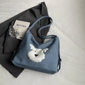 Borsa tote in denim blu con ricamo a cucciolo di peluche su sfondo di abito grigio - Blu