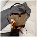 Detail of canvas bucket bag featuring a brown teddy bear charm and gold twist-lock - Grey Coffee With Pendant