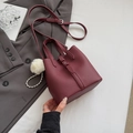 Minimalistische weinrote Beuteltasche aus genarbtem Leder mit Tragegriffen und Perlenanhänger - Rot mit Anhänger
