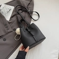 Minimalistische schwarze Eimer-Tasche aus Leder mit Griff und Plüsch-Perlenanhänger - Schwarz mit Anhänger