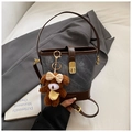 Detailed macro view of denim bucket bag with brown leather trim and metallic buckle closure - Blue with Charm