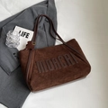 Detailansicht der braunen Wildledertasche mit MOACHI-Schriftzug und kleinem Bären-Anhänger - Kaffeebraun