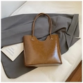 Minimalistische vintage bruine tote bag met slanke banden in een zakelijke setting - Bruin