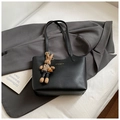 Dettaglio della borsa tote nera in pelle con logo dorato e ciondolo a forma di coniglio - Con Ciondolo / Nero