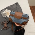 Detalle del bolso bandolera de mezclilla y cuero marrón con logo plateado de ZHCNMA - Marrón