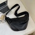 Flat lay of large black nylon crossbody bag with adjustable strap and casual accessories - Black Large